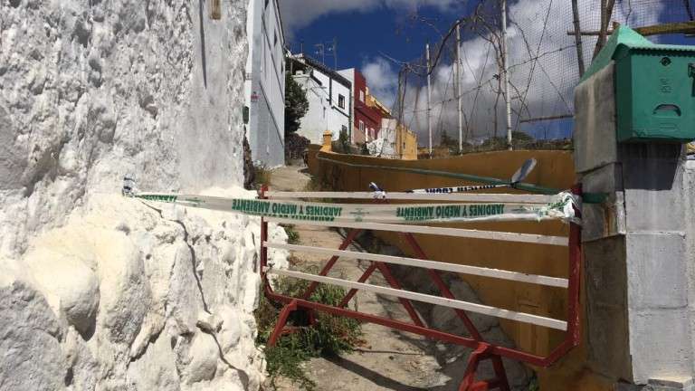 Vista del sendero afectado por un derrumbe. Hacia arriba, a la izquierda, casas aisladas por el corte.